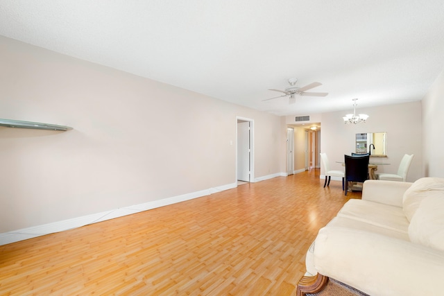 living room featuring wood-type flooring and ceiling fan with notable chandelier