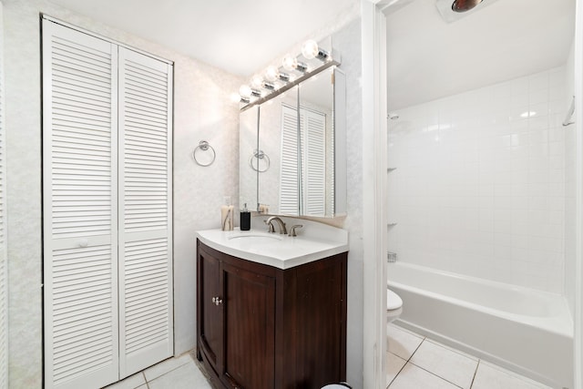 full bathroom featuring tiled shower / bath, vanity, toilet, and tile patterned flooring