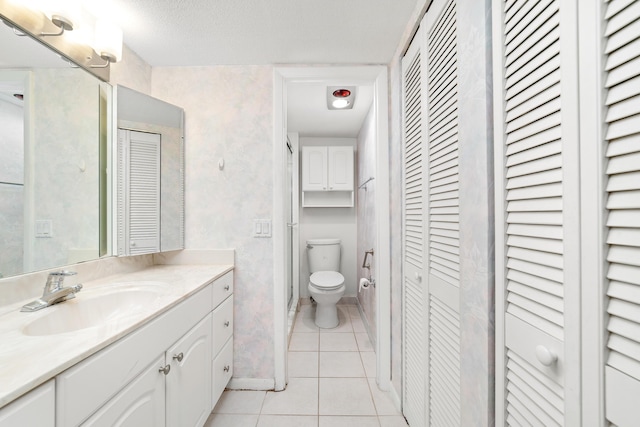 bathroom featuring vanity, toilet, and tile patterned flooring