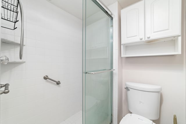 bathroom featuring toilet and an enclosed shower