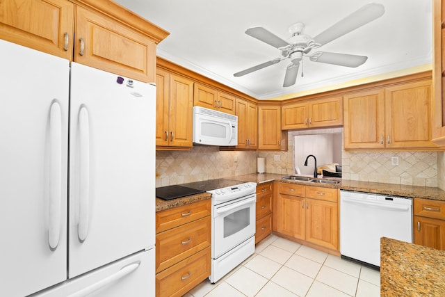 kitchen with sink, white appliances, light tile patterned floors, and stone counters