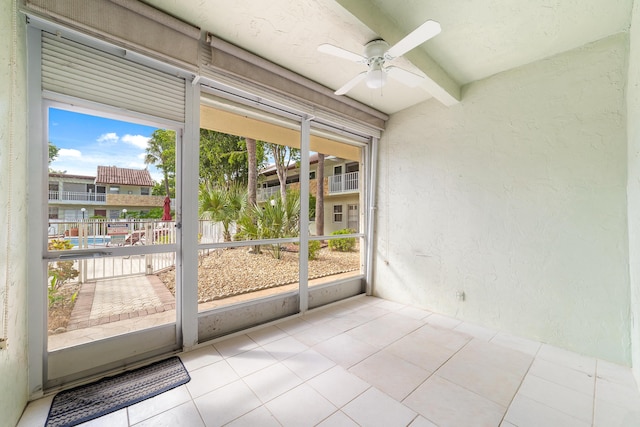 entryway featuring beamed ceiling, ceiling fan, and light tile patterned flooring