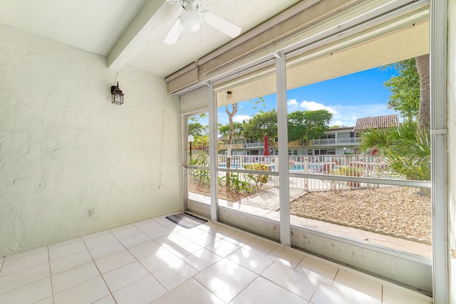 unfurnished sunroom featuring ceiling fan and a healthy amount of sunlight