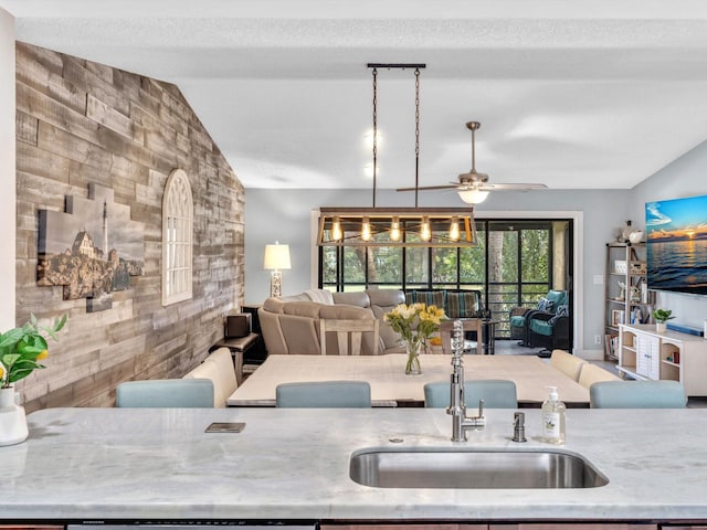 kitchen featuring lofted ceiling, decorative light fixtures, sink, and ceiling fan