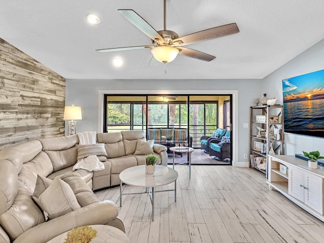 living room featuring light hardwood / wood-style floors, lofted ceiling, a wealth of natural light, and ceiling fan