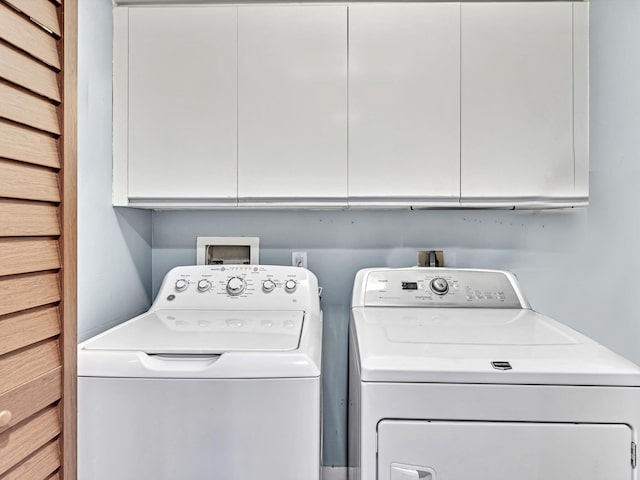 laundry area featuring washing machine and dryer and cabinets