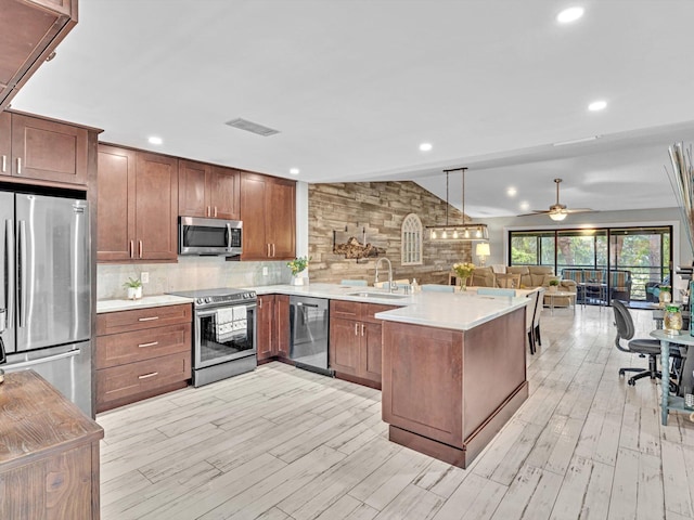 kitchen featuring sink, light wood-type flooring, ceiling fan, stainless steel appliances, and lofted ceiling