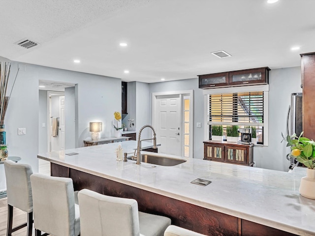 kitchen featuring a kitchen breakfast bar, sink, light hardwood / wood-style flooring, and kitchen peninsula