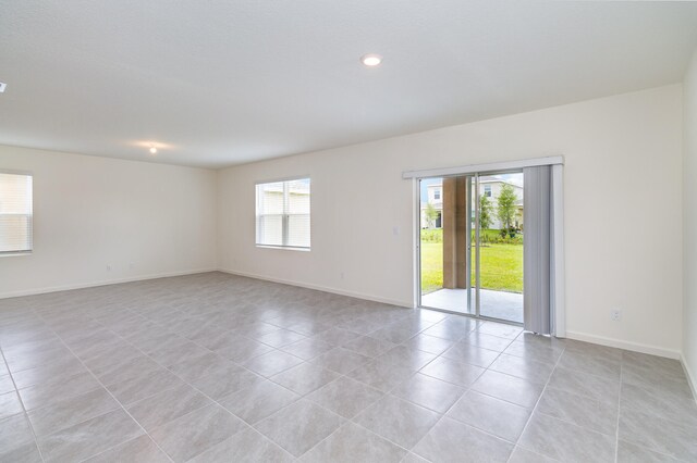 spare room with light tile patterned flooring and plenty of natural light