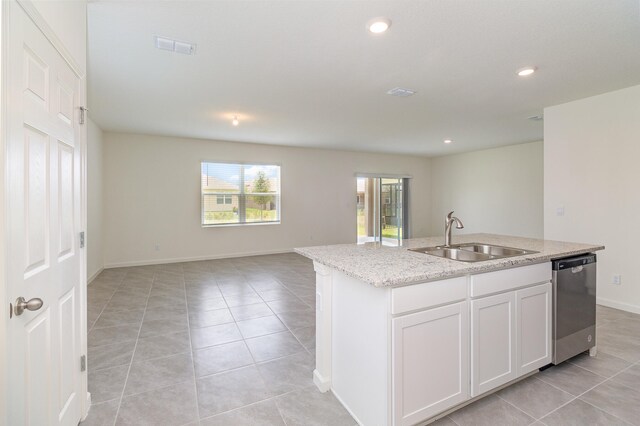 kitchen featuring sink, dishwasher, white cabinetry, and an island with sink