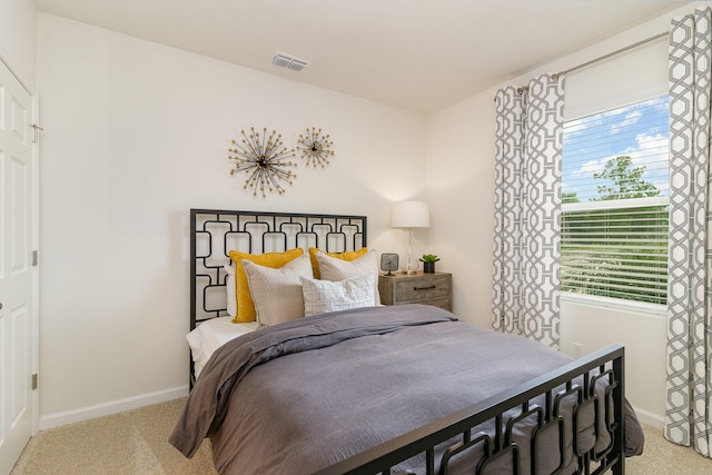 bedroom featuring light carpet and multiple windows