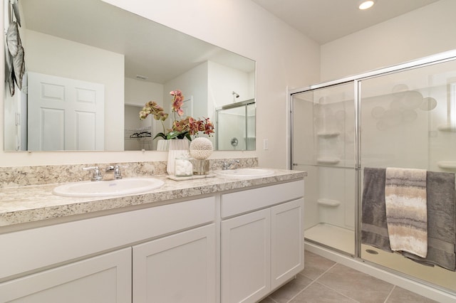 bathroom with vanity, a shower with shower door, and tile patterned flooring