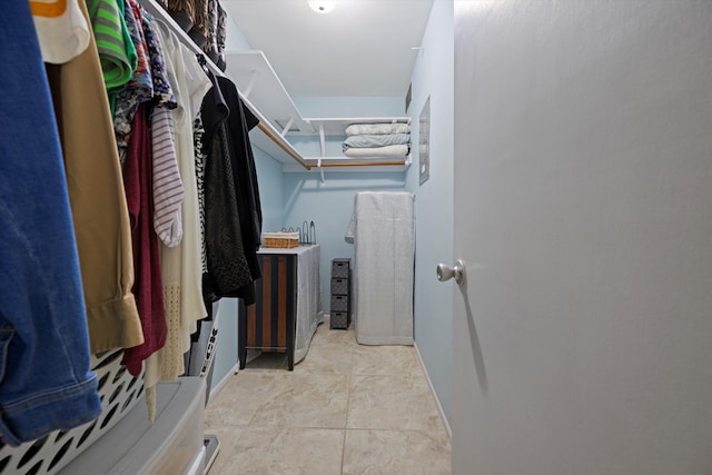 spacious closet with light tile patterned floors