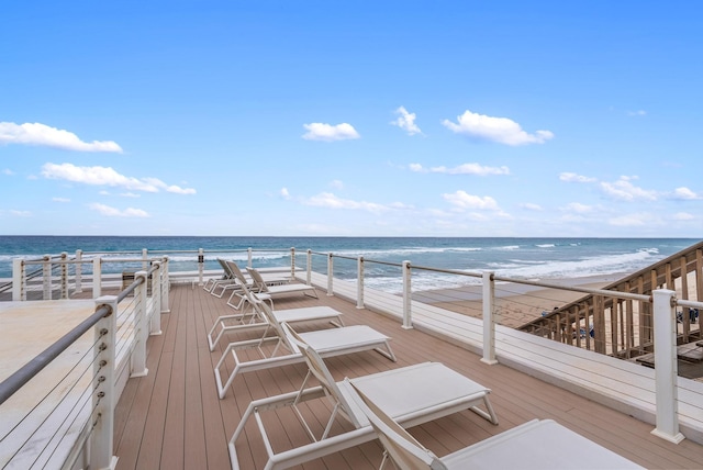 wooden terrace with a water view and a view of the beach