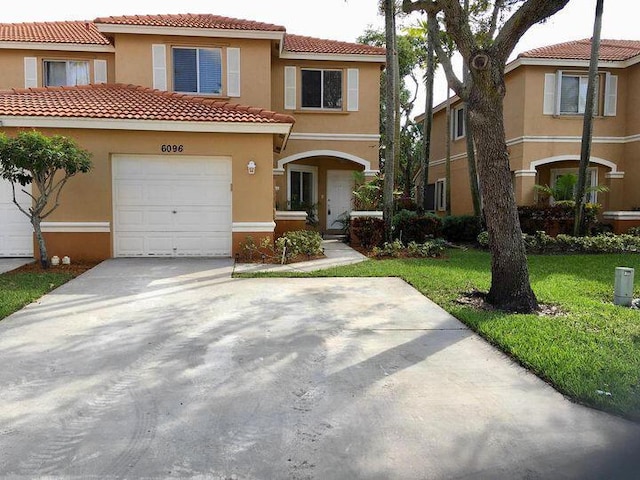 mediterranean / spanish house featuring a garage and a front yard