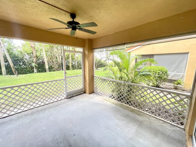 unfurnished sunroom with ceiling fan