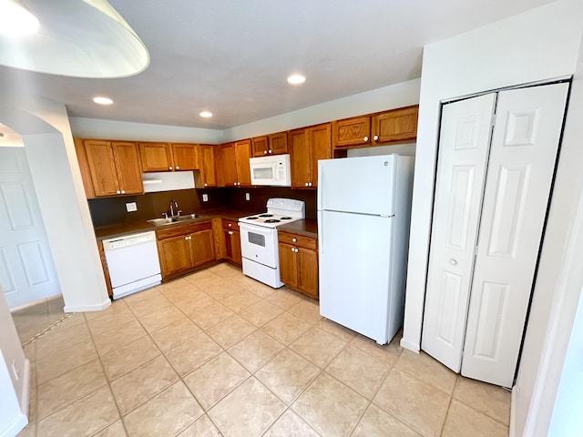 kitchen with light tile patterned flooring, sink, white appliances, and decorative backsplash