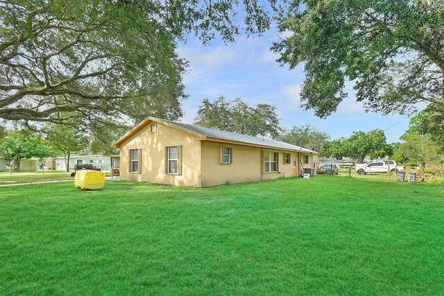 view of side of home with a lawn