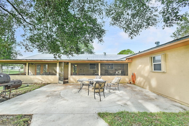 rear view of house with a patio and a sunroom