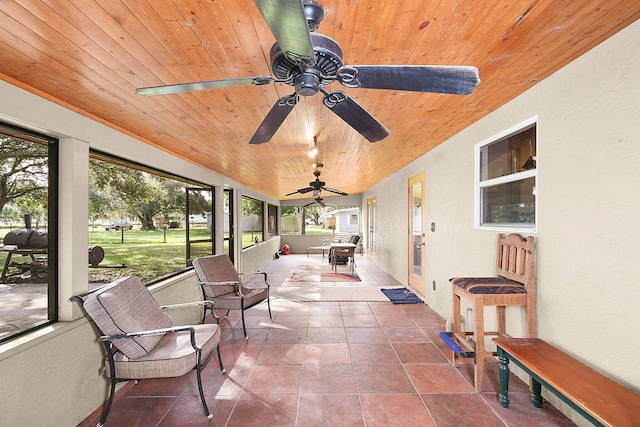 sunroom with wood ceiling and ceiling fan