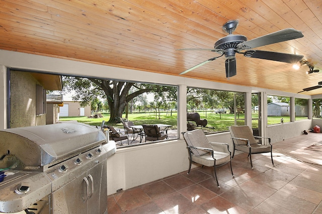 sunroom featuring ceiling fan and wooden ceiling