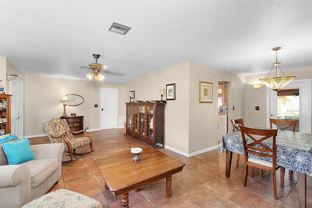 tiled living room with a textured ceiling and ceiling fan