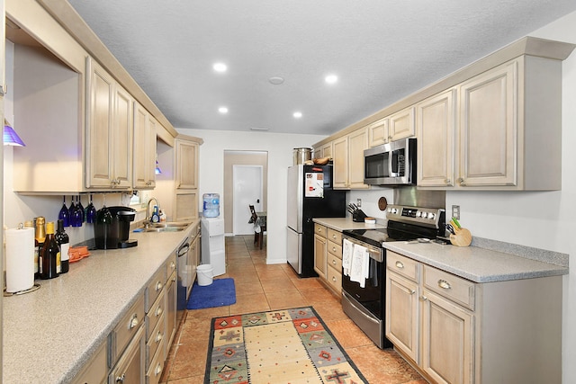 kitchen featuring light tile patterned floors, sink, and appliances with stainless steel finishes