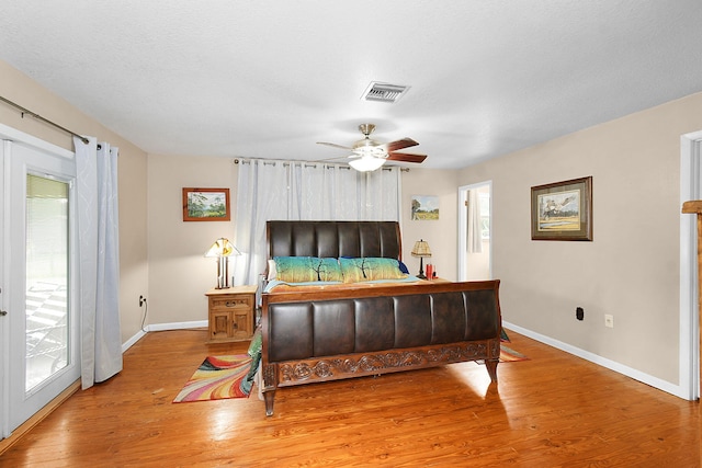 bedroom with hardwood / wood-style flooring, ceiling fan, multiple windows, and access to outside