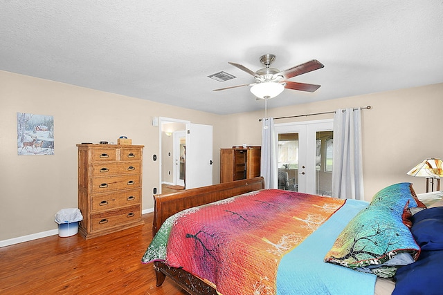 bedroom featuring french doors, access to outside, wood-type flooring, a textured ceiling, and ceiling fan