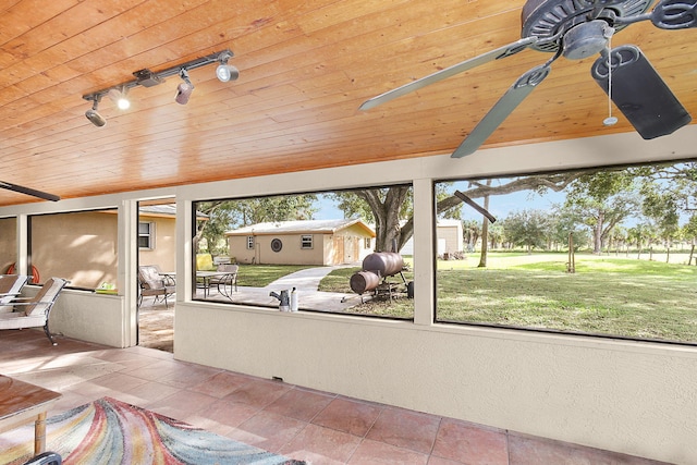 unfurnished sunroom featuring rail lighting and wooden ceiling