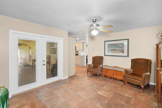 sitting room featuring a textured ceiling, french doors, and ceiling fan