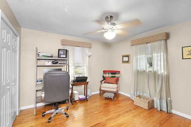 home office featuring ceiling fan, a textured ceiling, and light hardwood / wood-style floors