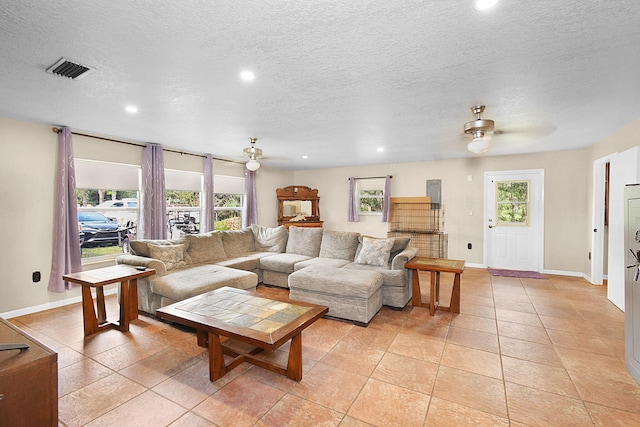 tiled living room with ceiling fan and a textured ceiling