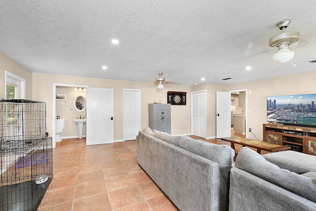 living room featuring a textured ceiling and ceiling fan