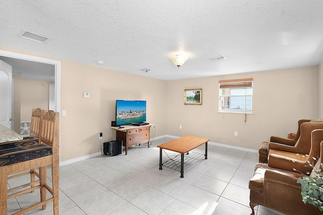 tiled living room featuring a textured ceiling