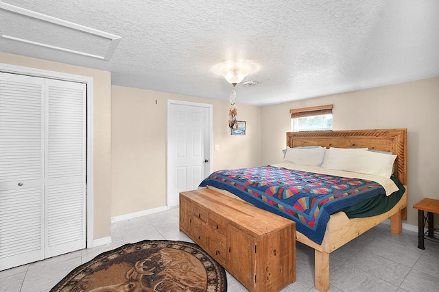 tiled bedroom with a closet and a textured ceiling