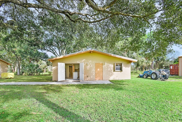 rear view of house featuring a yard and a patio area