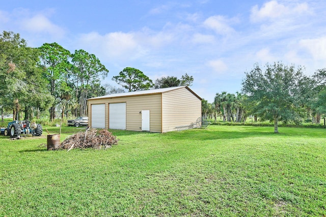 view of yard with a garage and an outbuilding