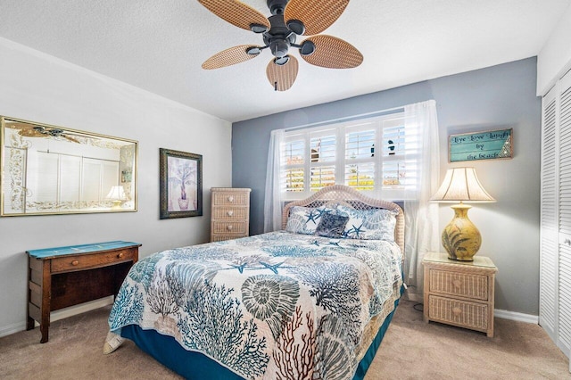 carpeted bedroom featuring a textured ceiling, a closet, and ceiling fan