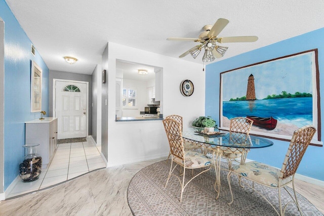 dining room with a textured ceiling and ceiling fan