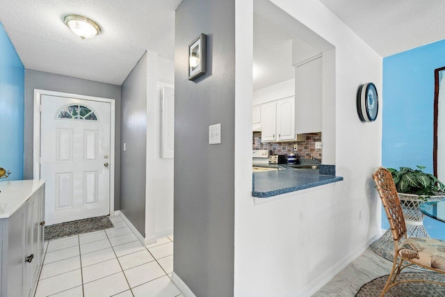 tiled entrance foyer with a textured ceiling