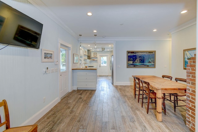 dining space featuring light hardwood / wood-style floors and ornamental molding