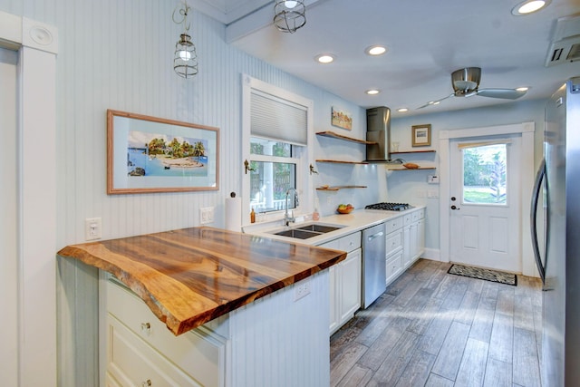 kitchen featuring pendant lighting, dark wood-type flooring, exhaust hood, white cabinets, and butcher block countertops