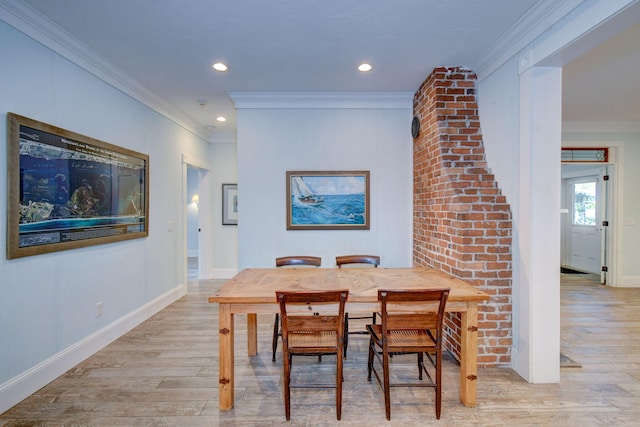 dining space with ornate columns, crown molding, and light hardwood / wood-style flooring