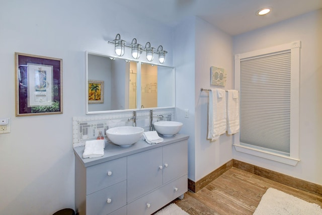 bathroom featuring hardwood / wood-style floors, vanity, and decorative backsplash