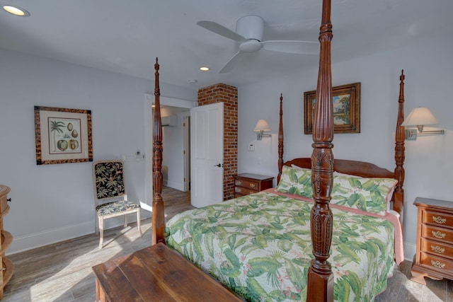 bedroom featuring hardwood / wood-style floors, ceiling fan, and a wall mounted AC