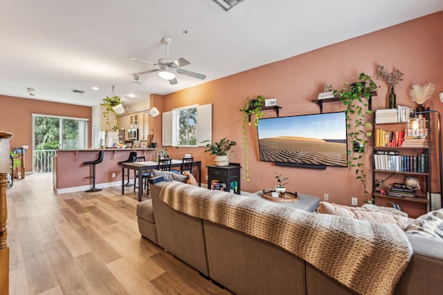 living room featuring ceiling fan and light hardwood / wood-style flooring