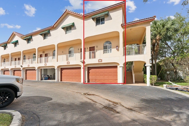 mediterranean / spanish home with a garage and a balcony