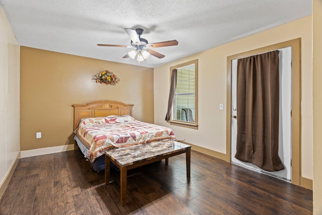 bedroom featuring dark wood-type flooring, a textured ceiling, and ceiling fan