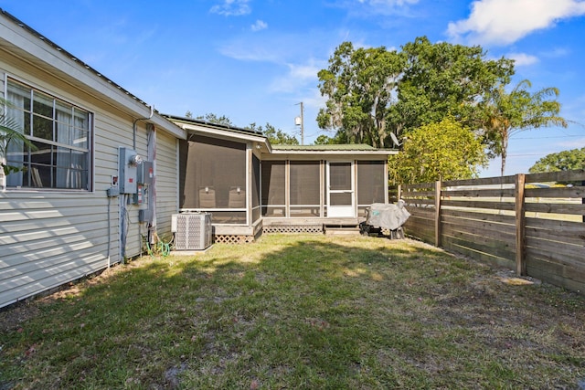 view of yard with central air condition unit and a sunroom